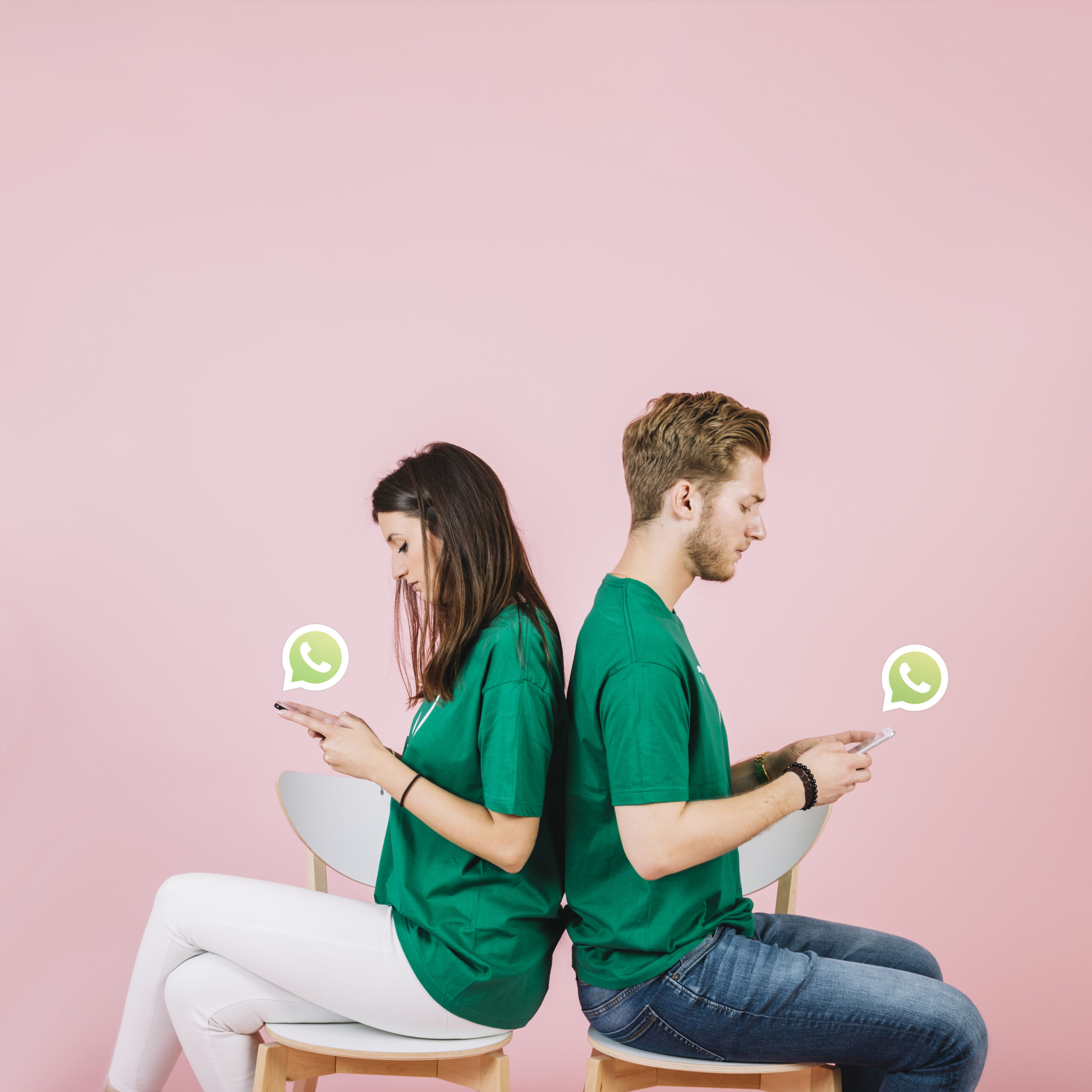 young-couple-sitting-back-back-using-whatsapp-smartphone